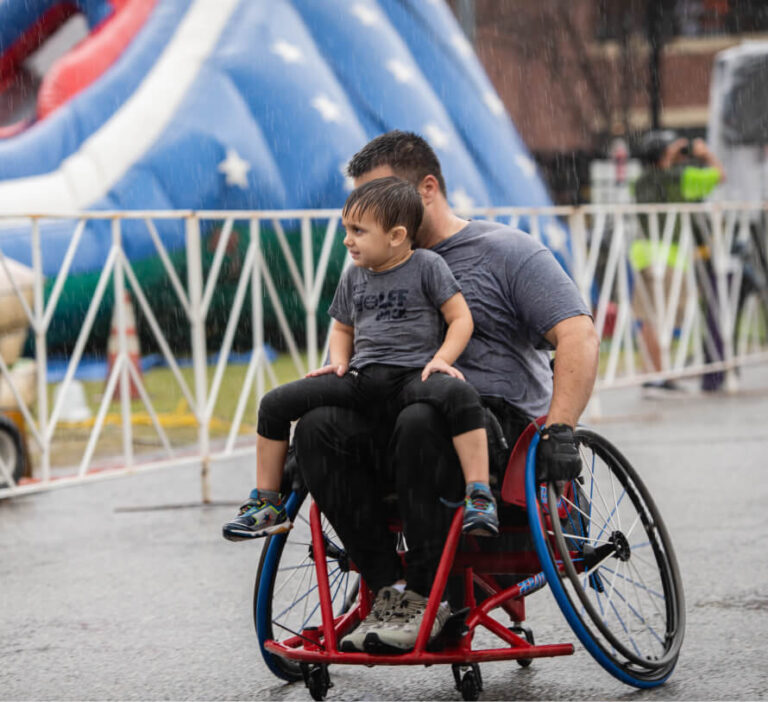 a father and son in his wheelchair during a race