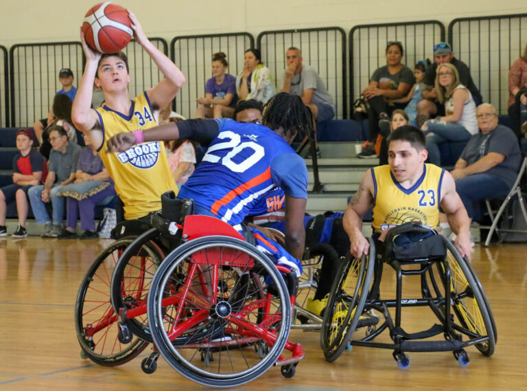 four adaptive sports basketball players during a game with one player about to take a shot