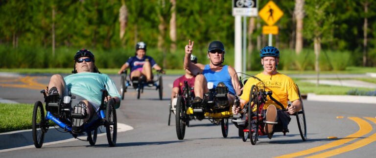 group of cyclists in their adaptive bicycles on a trail
